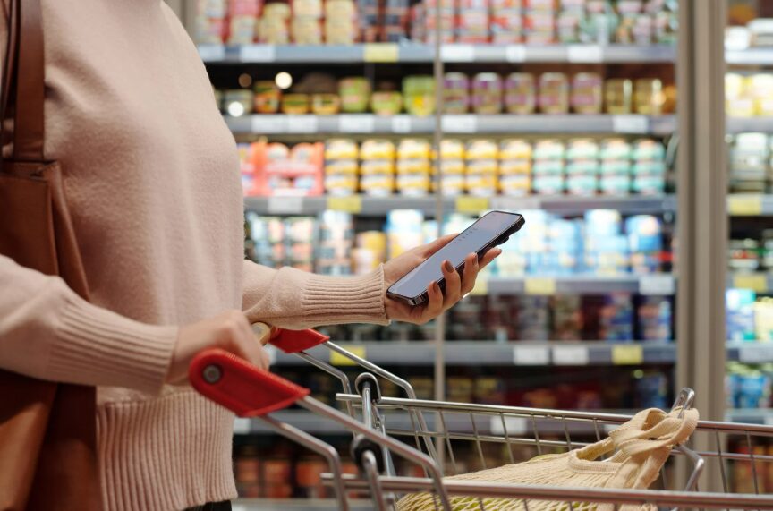 A shopper comparing grocery prices in an Austin supermarket aisle.
