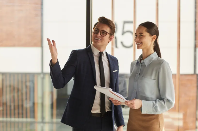 A professional real estate agent guiding a client through an apartment tour, explaining "how to become an apartment locator" and its benefits.