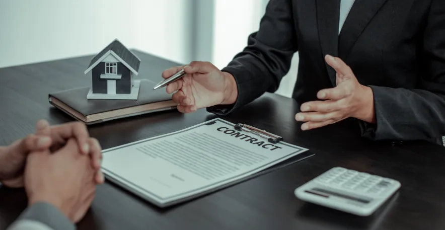 A real estate agent discussing a lease agreement with a client, highlighting negotiation tactics for how to get an apartment with bad credit.