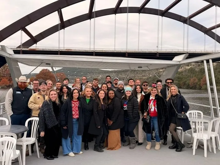 The One Place Locators team celebrating together on an Austin lake cruise