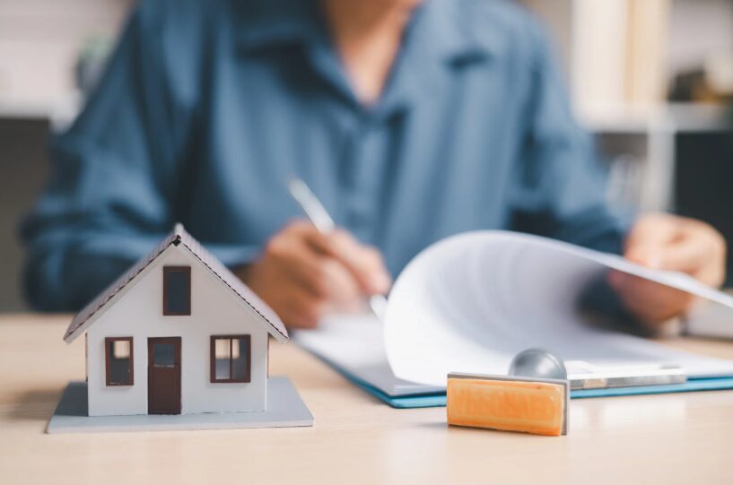 A renter reviewing and signing an apartment lease at a desk