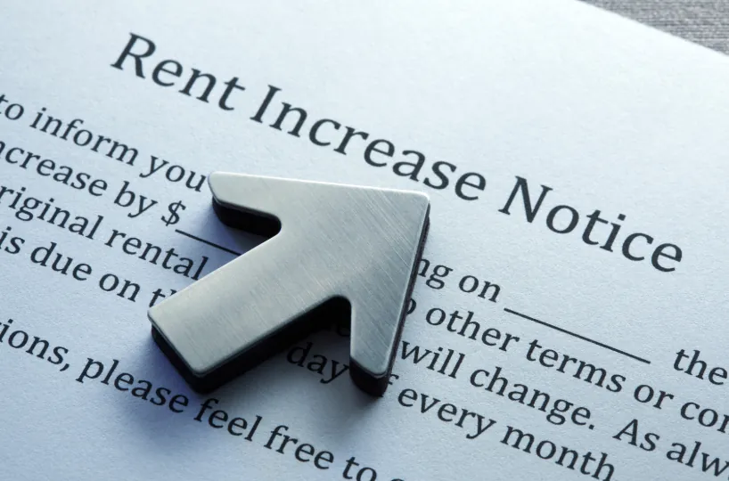 A close-up of a rent increase notice with an upward arrow, illustrating rising rental costs and factors influencing how much rent can i afford.