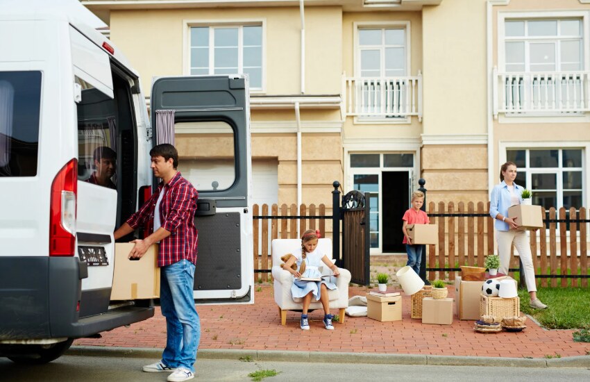 Renters unloading moving boxes outside their new home